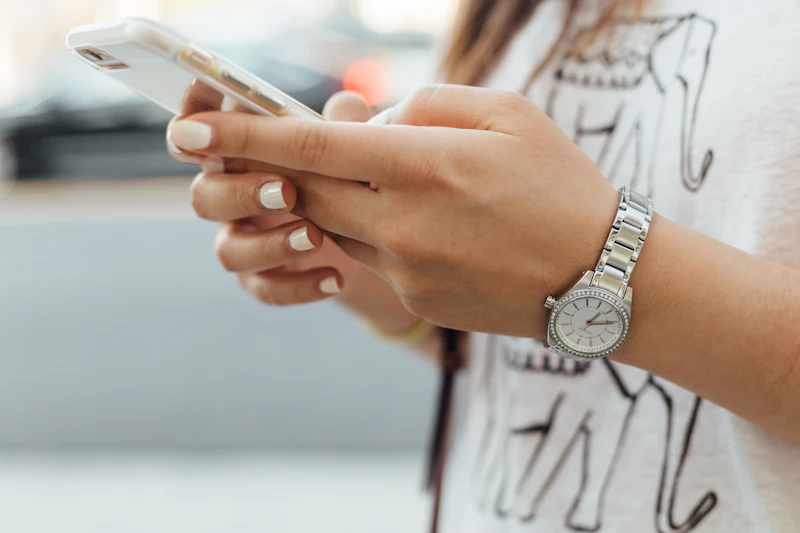 Person hält ein Smartphone in der Hand und scrollt durch eine Website