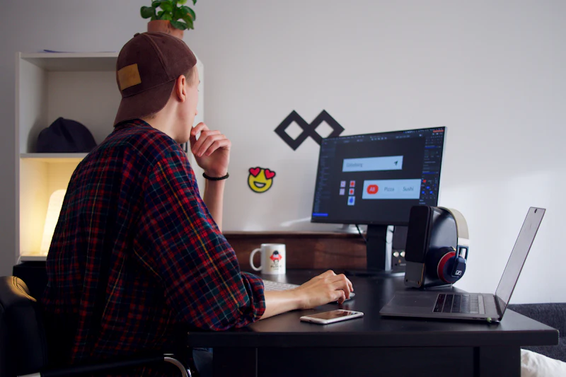 Mann arbeitet an einem Schreibtisch mit Computer an einem Website-Entwurf